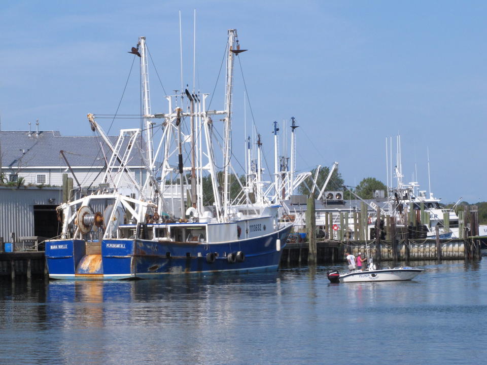 In this Sept. 11, 2019 photo, a commercial fishing boat is tied up at the dock at a seafood processing company in Point Pleasant Beach, N.J. Although they support effort to fight climate change and its impact on the world's oceans, the fishing industry fears it could be harmed by one of the promising solutions: the offshore wind energy industry. At a Congressional subcommittee hearing Monday Sept. 16, 2019 in New Jersey, fishermen asked for a seat at the table when important wind energy decisions are made, including where projects are located. (AP Photo/Wayne Parry)