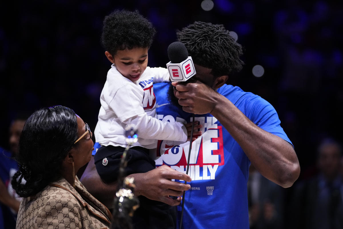 Joel Embiid breaks down in tears after his son runs out onto the field during the MVP presentation