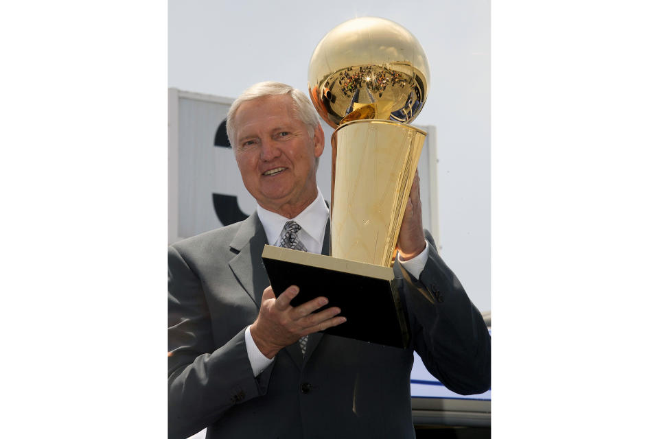 FILE - Former Los Angeles Lakers and Basketball Hall of Fame member Jerry West holds the Larry O'Brien championship trophy after it arrived at Los Angeles International Airport, on a Southwest Airlines, NBA-branded 737 named "Slam Dunk One,'' Monday, June 9, 2008, in Los Angeles. Jerry West, who was selected to the Basketball Hall of Fame three times in a storied career as a player and executive and whose silhouette is considered to be the basis of the NBA logo, died Wednesday morning, the Los Angeles Clippers announced. He was 86. (AP Photo/Damian Dovarganes, File)