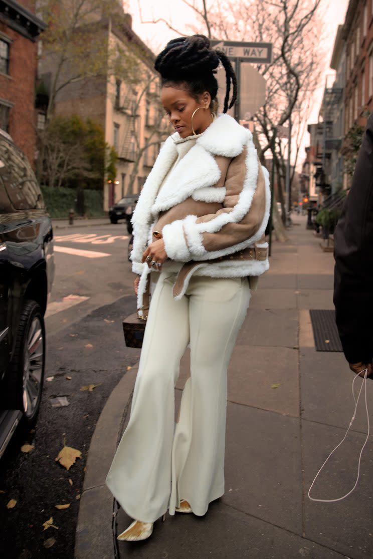 Rihanna stepped out in New York wearing a lambswool jacket, Louis Vuitton bag, and white pants. (Photo: Splash)