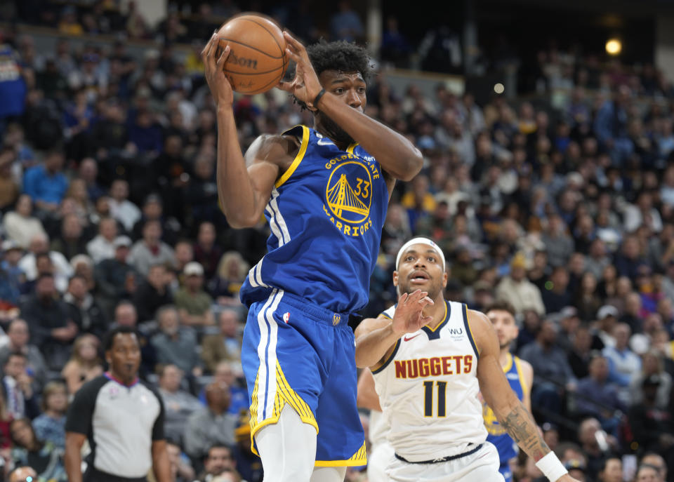 Golden State Warriors center James Wiseman, front, pulls in a rebound in front of Denver Nuggets forward Bruce Brown in the second half of an NBA basketball game Thursday, Feb. 2, 2023, in Denver. (AP Photo/David Zalubowski)