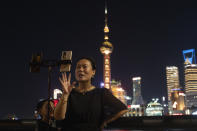 A woman livestreams from the bund in Shanghai, Wednesday, July 31, 2024. (AP Photo/Ng Han Guan)