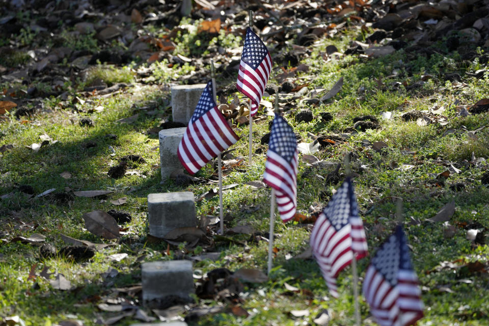 Small American flags are placed by the graves of the Civil War soldiers of the United States 1st Mississippi Infantry (African Descent) in Vicksburg National Cemetery, Feb. 14, 2024, in Vicksburg, Miss. Thirteen flags were placed at the graves of the Black soldiers killed in an 1864 massacre at Ross Landing who were buried as unknowns but have recently been identified. (AP Photo/Rogelio V. Solis)