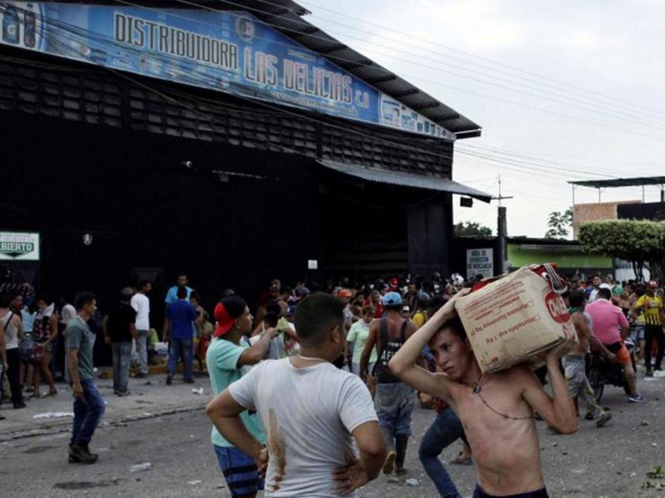 Looters stealing from a food wholesaler in La Fria (Reuters)