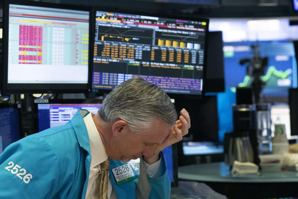 FILE - In this Wednesday, March 18, 2020 file photo, a trader holds his hand to his head after trading was halted at the New York Stock Exchange in New York. On March 23, 2020, the S&P 500 fell 2.9%. In all, the index dropped nearly 34% in about a month, wiping out three years’ worth of gains for the market. (AP Photo/Mark Lennihan)