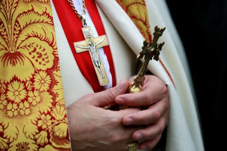 A priest holds a cross after a mass on Christmas at St George Chaldean Catholic Church in Baghdad, Iraq December 25, 2018. REUTERS/Thaier Al-Sudani