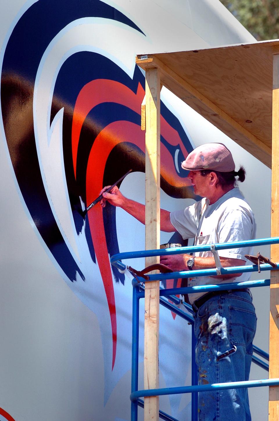Stockton artist Carlos Lopez works on painting a 15' x 18' mural of the University of the Pacific logo and name on one of the water tanks on Feather River Drive near I-5 in Stockton on Aug. 26, 2005. Lopez has already painted the logo of Stockton's indoor soccer team, the California Cougars ,on the tank and will paint the logo of Stockton's hockey team, The Stockton Thunder next week.