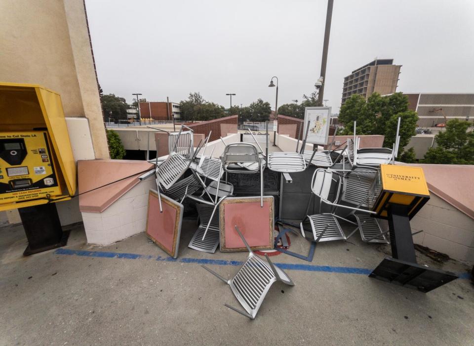 A barricade made of chairs and tables taken from campus blocks a walkway at a university.