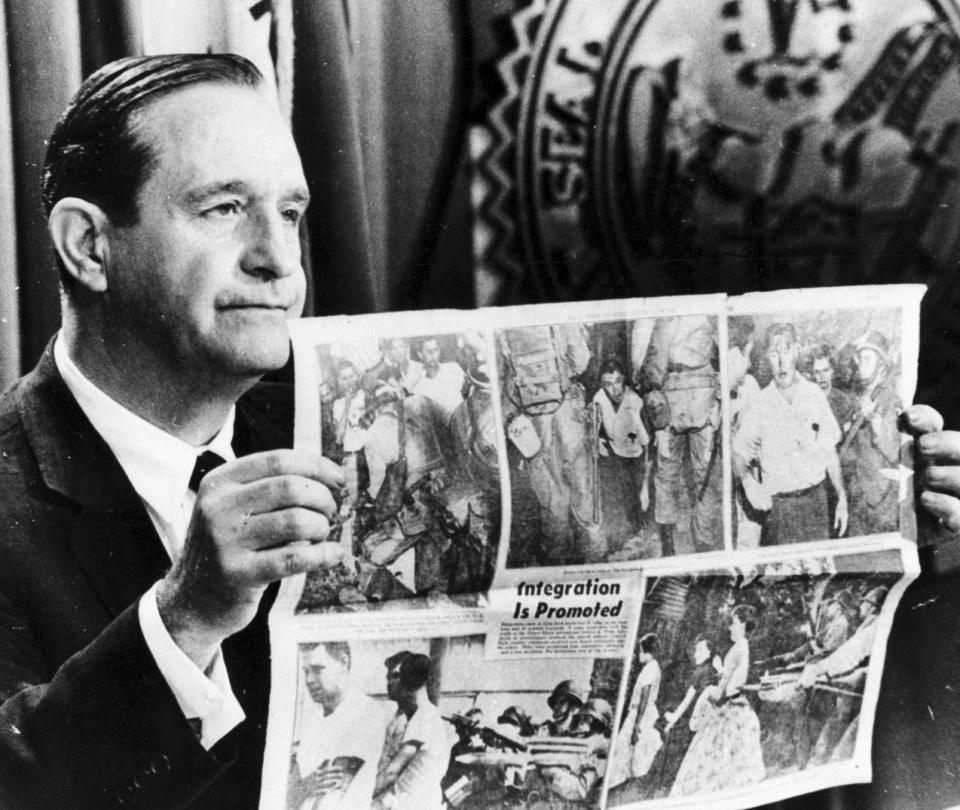 FILE - In this Aug. 23, 1957 file photo, Gov. Orval Faubus displays photos from Little Rock, printed in the New York Daily News, showing soldiers clamping down on disorderly whites in Little Rock, Ark. Faubus, who attempted to stop school desegregation by using the National Guard, referred to federal troops at Central High as occupation troops. Five decades and $1 billion after an infamous racial episode made Little Rock a symbol of school segregation, the legal fight to ensure all of its children receive equal access to education has ended. (AP Photo/File)