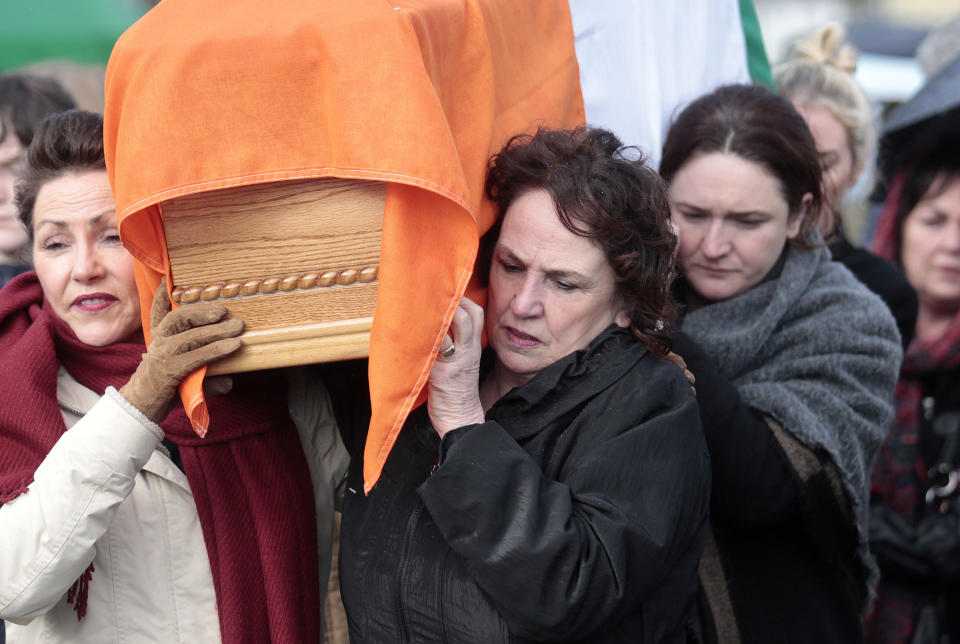 Bernie McGuinness, right, carries the coffin of her husband Martin back to their home in the bogside area of Londonderry, Northern Ireland, Tuesday, March, 21, 2017. Martin McGuinness, the Irish Republican Army warlord who led his underground, paramilitary movement toward reconciliation with Britain, and was Northern Ireland's deputy first minister for a decade in a power-sharing government, has died, his Sinn Fein party announced Tuesday on Twitter. He was 66.(AP Photo/Peter Morrison)