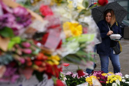A woman pays her respects at a makeshift memorial on Yonge Street following a van that attacked multiple people in Toronto, Ontario, Canada, April 25, 2018. REUTERS/Carlo Allegri