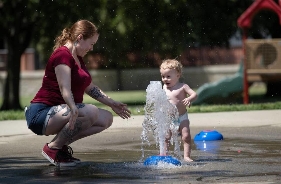 Jessika Van Winkle plays in the water with her 1-year-old son Ezekiel in the water feature at Marshall Park in Modesto, Calif., Thursday, June 1, 2023. Andy Alfaro/aalfaro@modbee.com