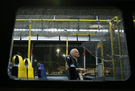 A person sits on an official media bus after a window shattered when driving accredited journalists to the Main Transport Mall from the Deodoro venue of the Rio 2016 Olympic Games in Rio de Janeiro, August 9, 2016. REUTERS/Shannon Stapleton