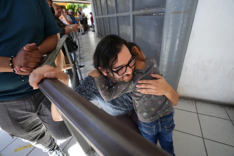 Luis Valencia, a legal assistant, hugs a young migrant from Oaxaca as she waits with her mother and siblings in Nogales, Sonora, on May 12, 2023, for their CBP One with U.S. Customs and Border Protection at the Dennis DeConcini Port of Entry.