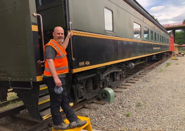 Cory Clark stands in front of the Kamloops Heritage Railway’s decommissioned No. 406 railroad car. The car is being turned into a classroom to allow the Heritage Railway to host field trips starting in September 2021. (Brendan Coulter/CBC - image credit)