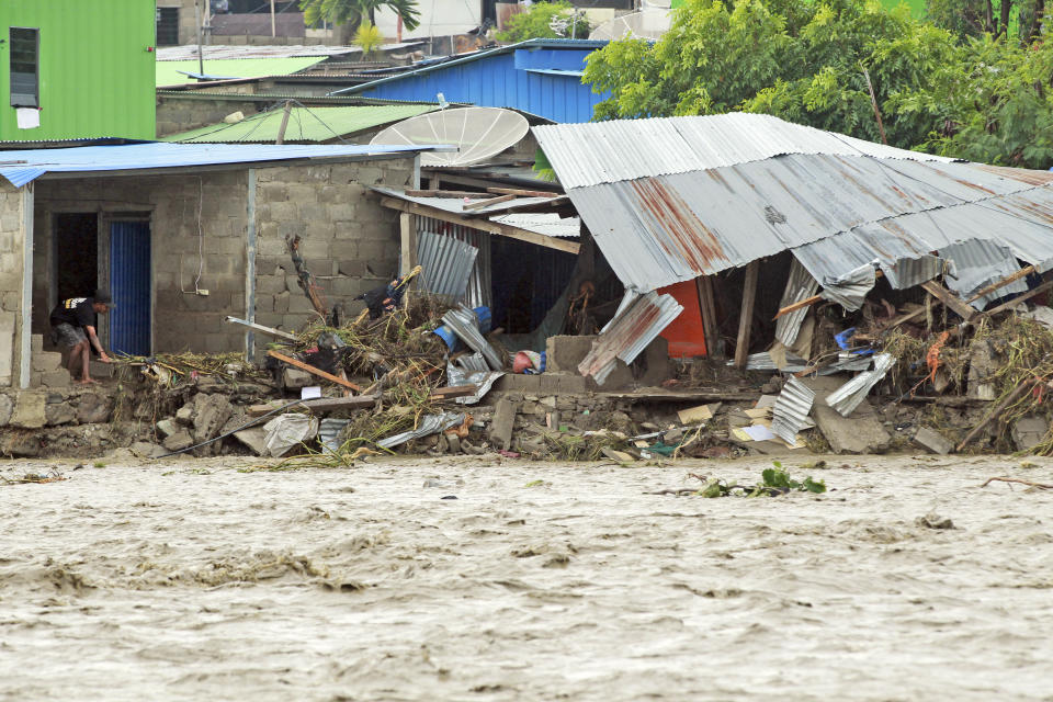 A man inspects buildings damaged by a flood in Dili, East Timor, Monday, April 5, 2021. Multiple disasters caused by torrential rains in eastern Indonesia and neighboring East Timor have left dozens of people dead and missing and displaced thousands. (AP Photo/Kandhi Barnez)