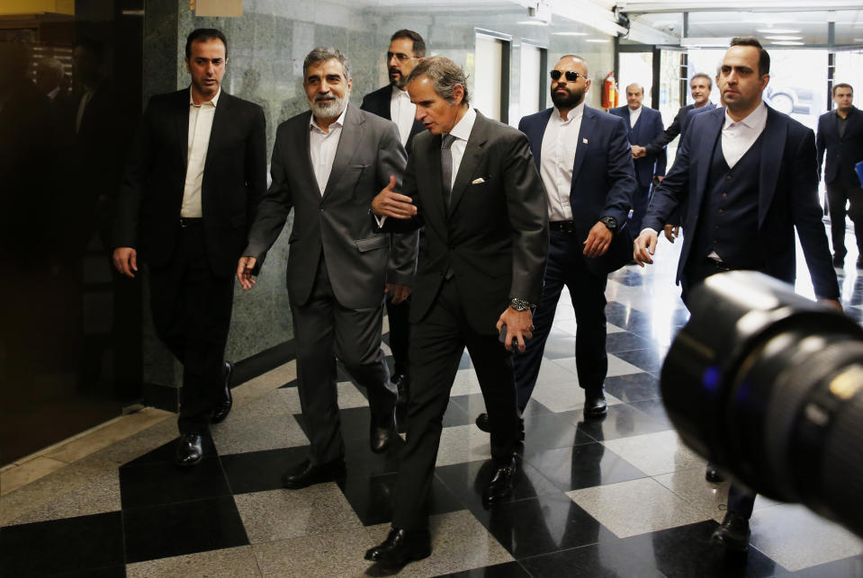 International Atomic Energy Organization, IAEA, Director General Rafael Mariano Grossi, center, arrives for a meeting with head of Atomic Energy Organization of Iran Mohammad Eslami as he is welcomed by the spokesman for Iran's atomic agency Behrouz Kamalvandi, second left, in Tehran, Saturday, March 4, 2023. (AP Photo/Vahid Salemi)