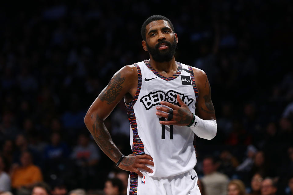 Kyrie Irving stands on a basketball court.