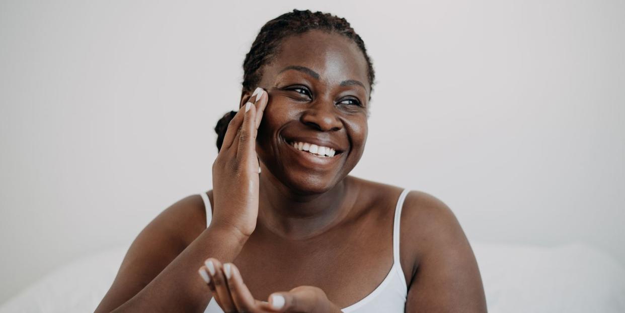 skin care using cosmetic skin cream woman with black skin