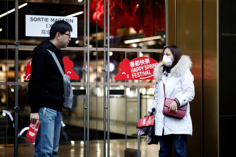 Tourist wears a protective mask as she leaves the Galeries Lafayette department store in Paris as the country is hit by the new coronavirus