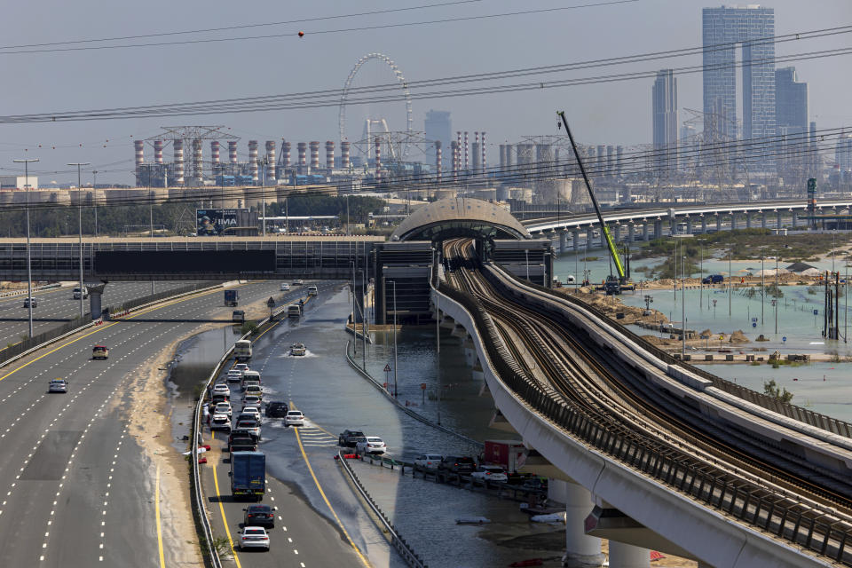 Vehicles drive through standing floodwater caused by heavy rain on Sheikh Zayed Road highway in Dubai, United Arab Emirates, Thursday, April 18, 2024. The United Arab Emirates attempted to dry out Thursday from the heaviest rain the desert nation has ever recorded, a deluge that flooded out Dubai International Airport and disrupted flights through the world's busiest airfield for international travel. (AP Photo/Christopher Pike)