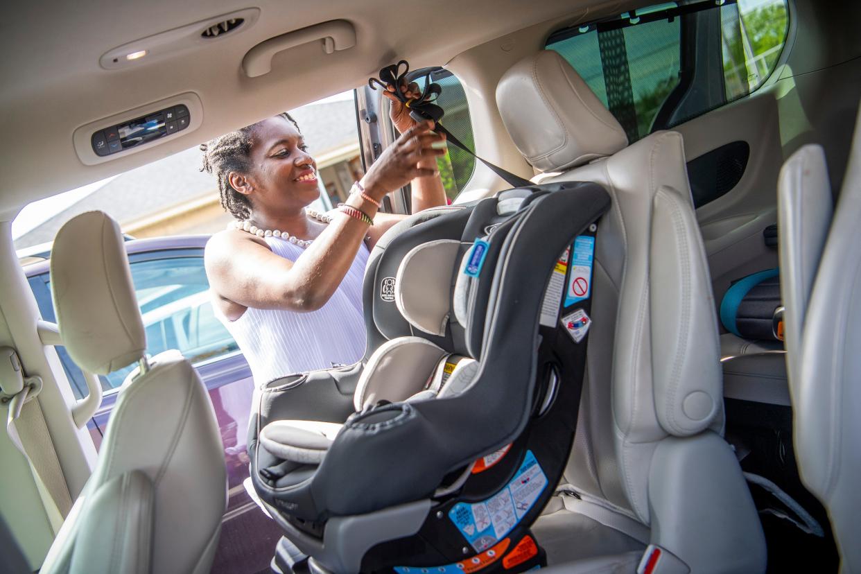 Yvonne Hensley, access collaboration and equity director of Tandem Community Birth Center & Postpartum House, installs a child seat into a TanGo outreach vehicle on Thursday, April 18, 2024.