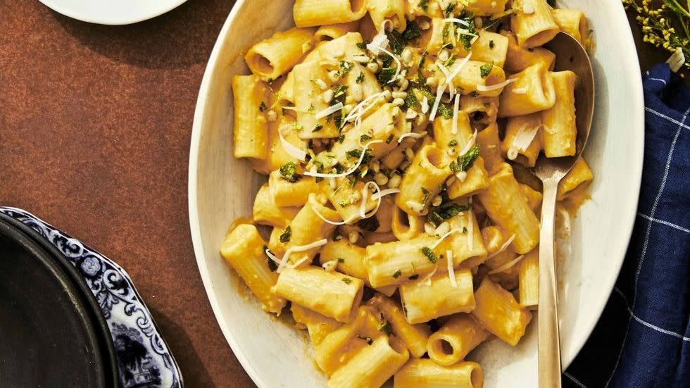 creamy pumpkin pasta with pine nut gremolata in a bowl with a spoon