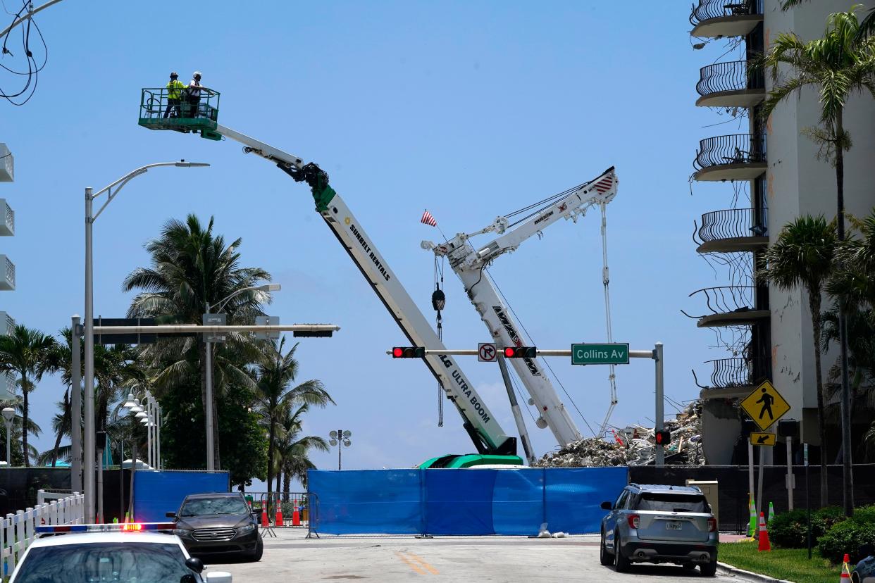 Workers are on the site of the Champlain Towers South condo building, where scores of victims remain missing more than a week after it partially collapsed, Sunday, July 4, 2021, in Surfside, Fla. Demolition teams are preparing to bring down the unstable remainder of the structure ahead of a tropical storm.