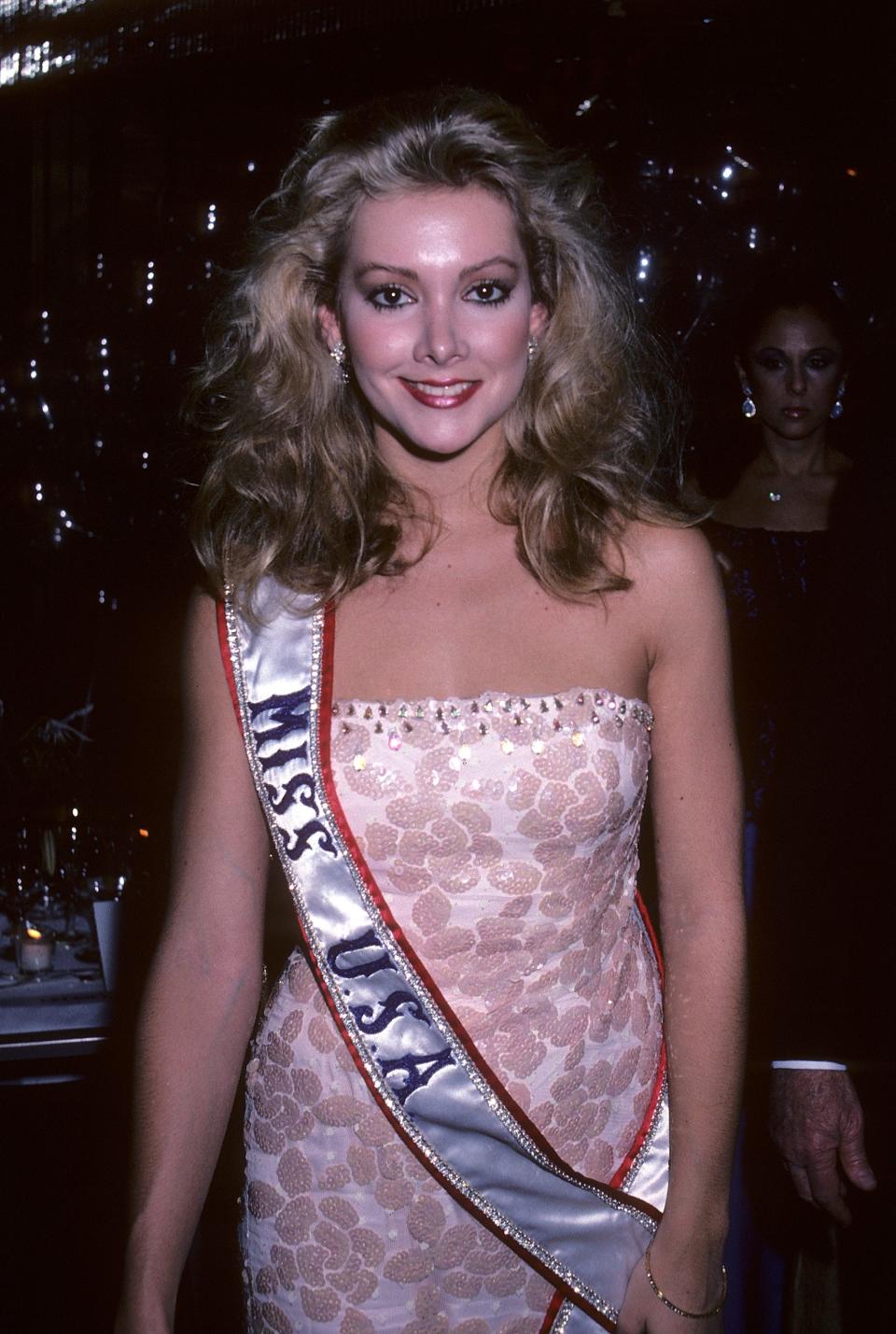 Miss USA 1981 Kim Seelbrede smiles and wears a Miss USA pageant.