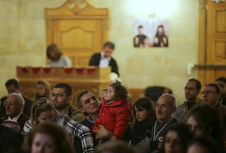 Syrian Christans look on during the mass at the Greek Orthodox church in the Syrian government controlled area of Aleppo on November 16, 2014