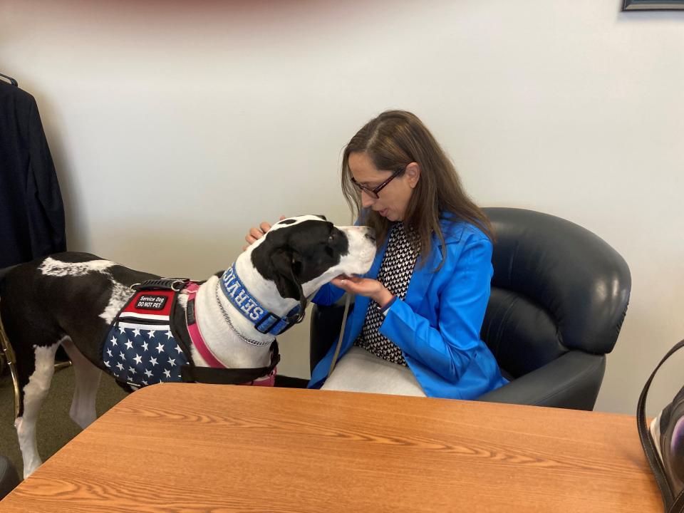 Veteran agent Micaili Britto and service dog, Rabbit, in their new office in One Government Center