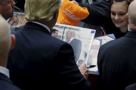 U.S. Republican presidential candidate Donald Trump autographs a photograph of himself and fellow candidate U.S. Senator Ted Cruz at a campaign rally in Marshalltown, Iowa January 26, 2016. REUTERS/Brian Snyder