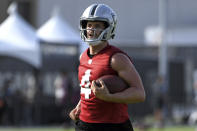 Las Vegas Raiders quarterback Derek Carr carries the ball during an NFL football practice Thursday, July 29, 2021, in Henderson, Nev. (AP Photo/David Becker)