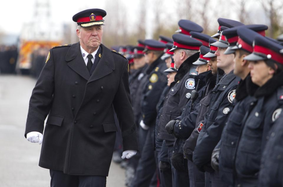 Toronto police chief Blair walks by officers lining the roadway at the public memorial for police constable John Zivcic in Toronto