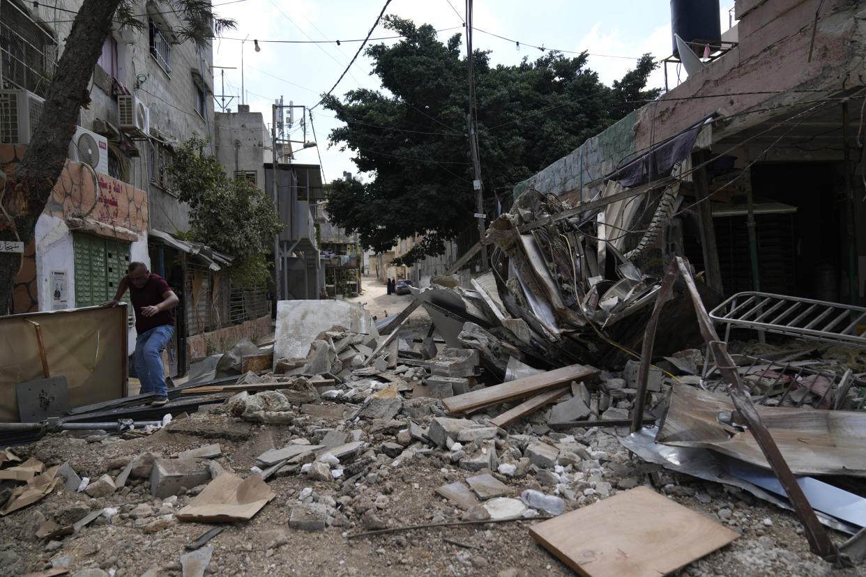 A Palestinian refugee walks through the rubble of a building that was destroyed during the Israeli army operation in the West Bank refugee camp of Tulkarem, in Tulkarem, Thursday, Sept. 5, 2024. (AP Photo/Nasser Nasser)