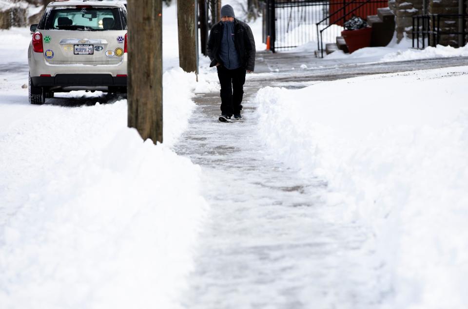 A pedestrian walks on the sidewalk in Price Hill on Sunday, Jan. 20, 2019.