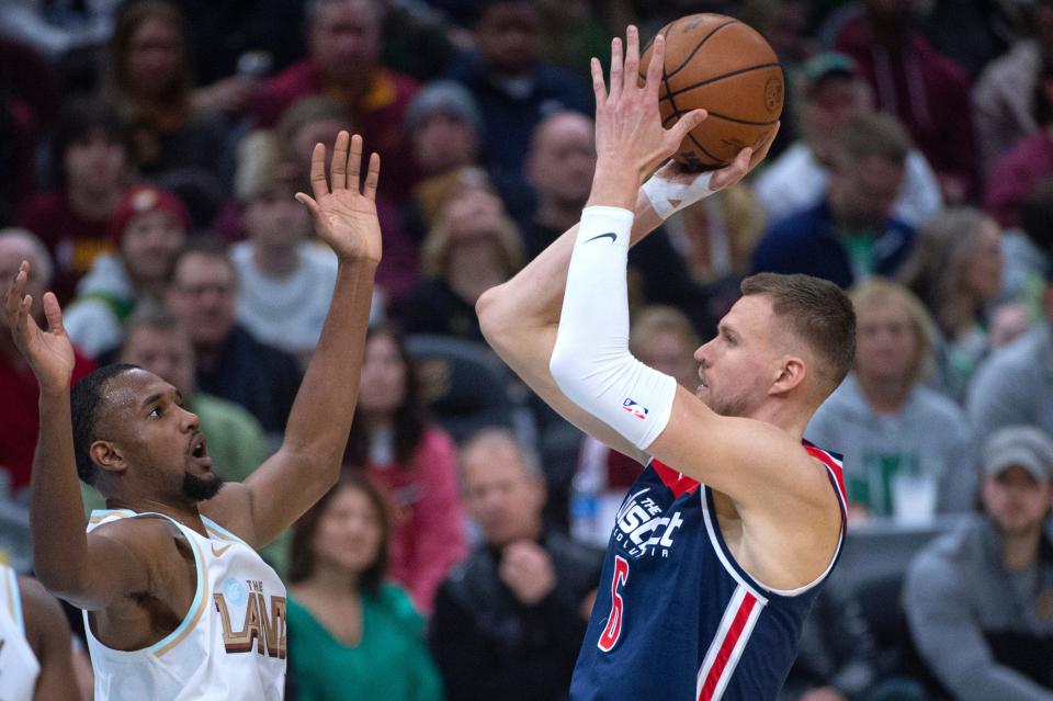 Washington Wizards' Kristaps Porzingis (6) shoots over Cleveland Cavaliers' Evan Mobley during the first half of an NBA basketball game in Cleveland, Friday, March 17, 2023. (AP Photo/Phil Long)