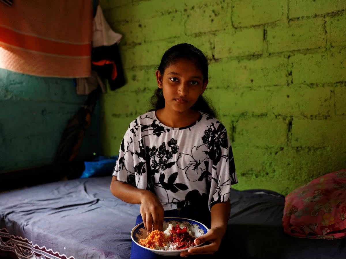 Dilhani Wathsala, 14, with her lunch. ‘Before the economic crisis, we ate well and we served meat or fish to our kids at least three or four times a week. Now fish is out of the reach of our family and so is meat,’ says her mother (Reuters)