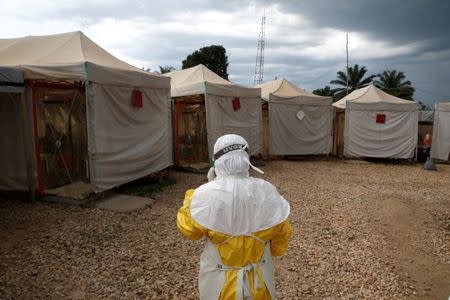 FILE PHOTO: A health worker wearing Ebola protection gear, walks before entering the Biosecure Emergency Care Unit (CUBE) at the ALIMA (The Alliance for International Medical Action) Ebola treatment centre in Beni, in the Democratic Republic of Congo, March 30, 2019. Picture taken March 30, 2019.REUTERS/Baz Ratner/File Photo