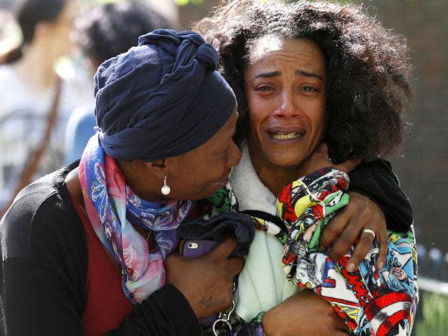 Pretana Morgan, right, the mother of shooting victim Rhyhiem Ainsworth Barton, 17, pictured being comforted by a family friend (Reuters)