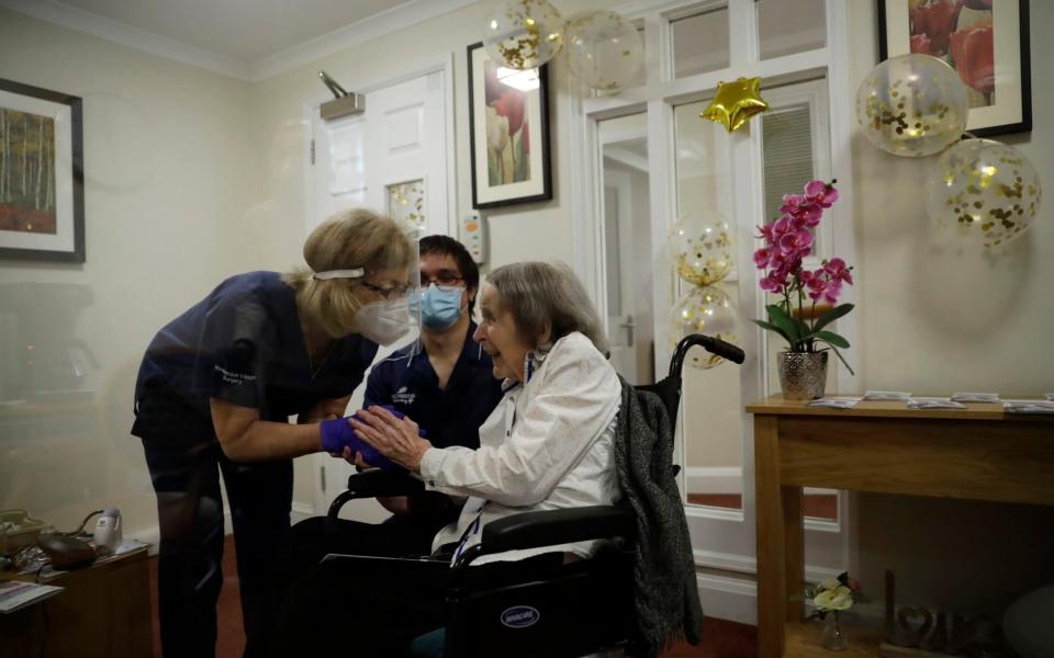 Care home resident Joan Potts, aged 102, is seen through a viewing screen installed for residents to safely receive visits from family members, as she speaks to Dr. Jane Allen after receiving her first dose of the Oxford/AstraZeneca COVID-19 vaccine at the Wimbledon Beaumont Care Home, run by Barchester, in south west London, Wednesday, Jan. 13, 2021, during England's third national lockdown since the coronavirus outbreak began.  - Matt Dunham/AP Photo