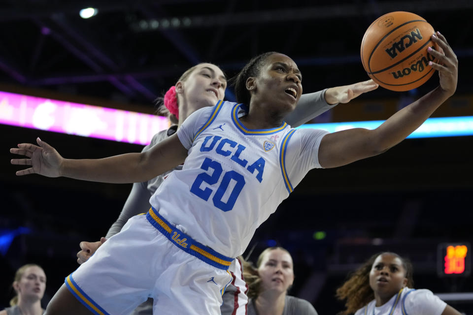 UCLA guard Charisma Osborne (20) grabs a rebound from Washington State center Emma Nankervis during the first half of an NCAA college basketball game in Los Angeles, Thursday, Feb. 23, 2023. (AP Photo/Ashley Landis)