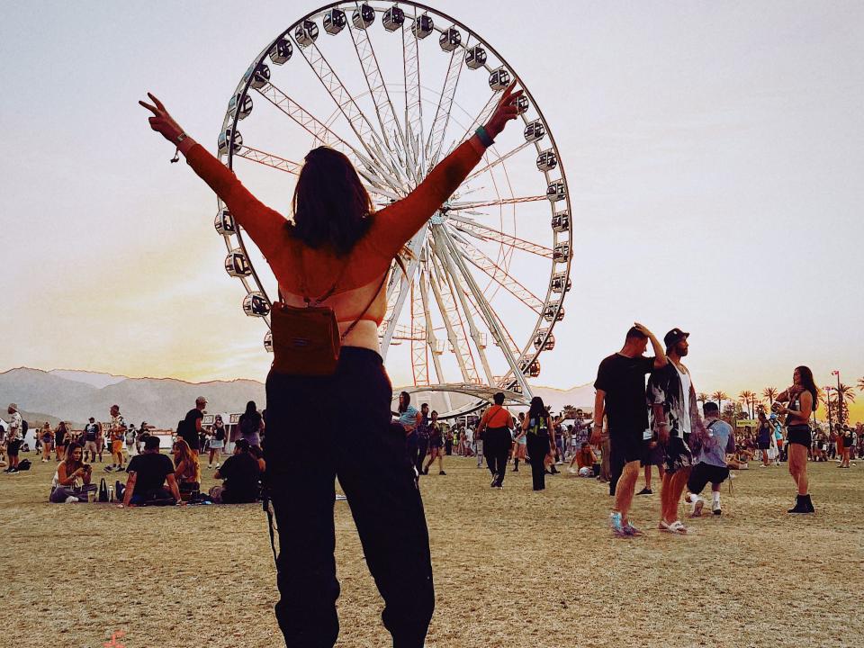 isabella rolz posing at coachella with back to the camera and ferris wheel in background