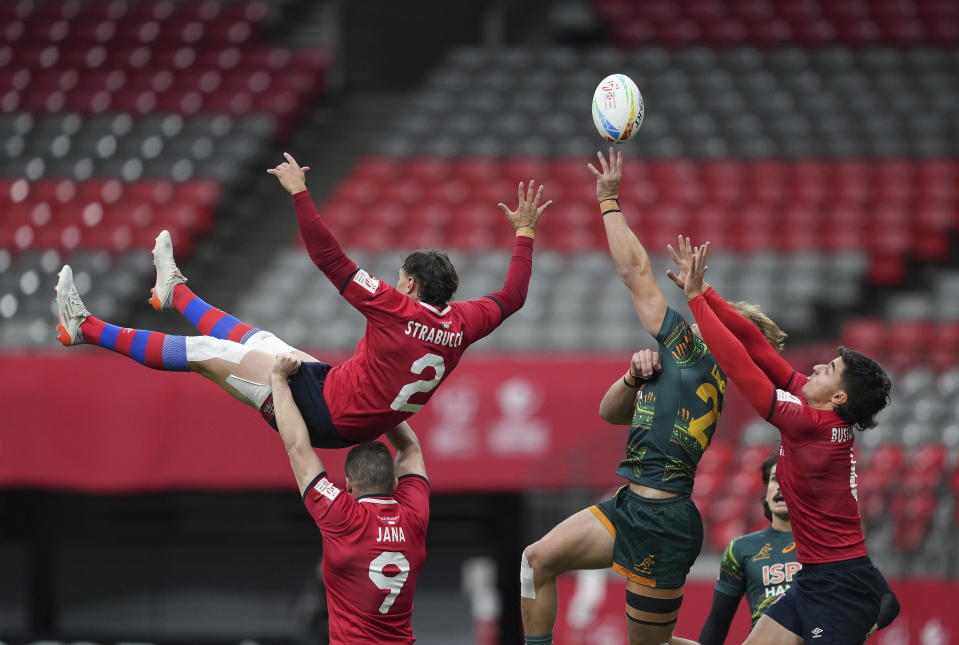 Australia's Darby Lancaster, second from front right, vies for the ball against Chile's Luca Strabucchi (2) and Manuel Bustamante, right, during a Canada Sevens rugby match in Vancouver, British Columbia, Friday, March 3, 2023. (Darryl Dyck/The Canadian Press via AP)
