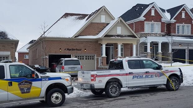 Emergency vehicles are seen parked near the home in Mount Albert where the Feb. 6 incident took place. Two people, including the 37-year-old suspect, died and three others survived knife attacks, including his two young sons.  (Michael Charles Cole/CBC - image credit)