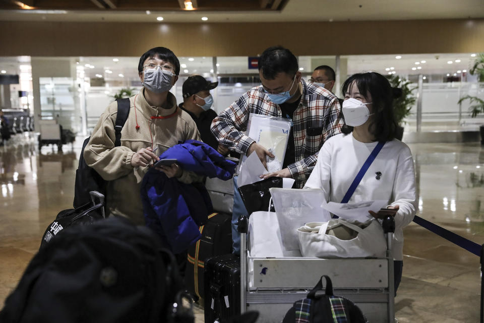 Foreign passengers wearing protective masks as precaution against the spread of the coronavirus arrive at Manila's International Airport, Philippines Thursday, Feb. 10, 2022. The Philippines lifted a nearly 2-year ban on foreign travelers Thursday in a lifesaving boost for its tourism and related industries as an omicron-fueled surge eases. (AP Photo/Basilio Sepe)