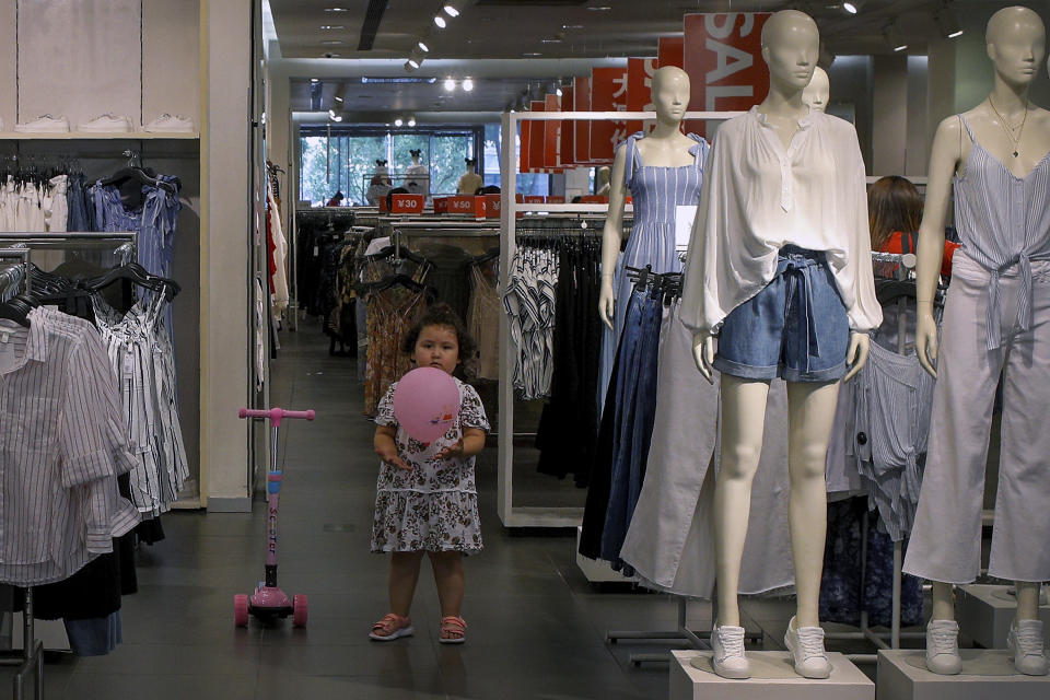 A child plays with a balloon at a clothing store having a promotion sale in Beijing, Monday, July 15, 2019. China's economic growth sank to its lowest level in at least 26 years in the quarter ending in June, adding to pressure on Chinese leaders as they fight a tariff war with Washington. (AP Photo/Andy Wong)