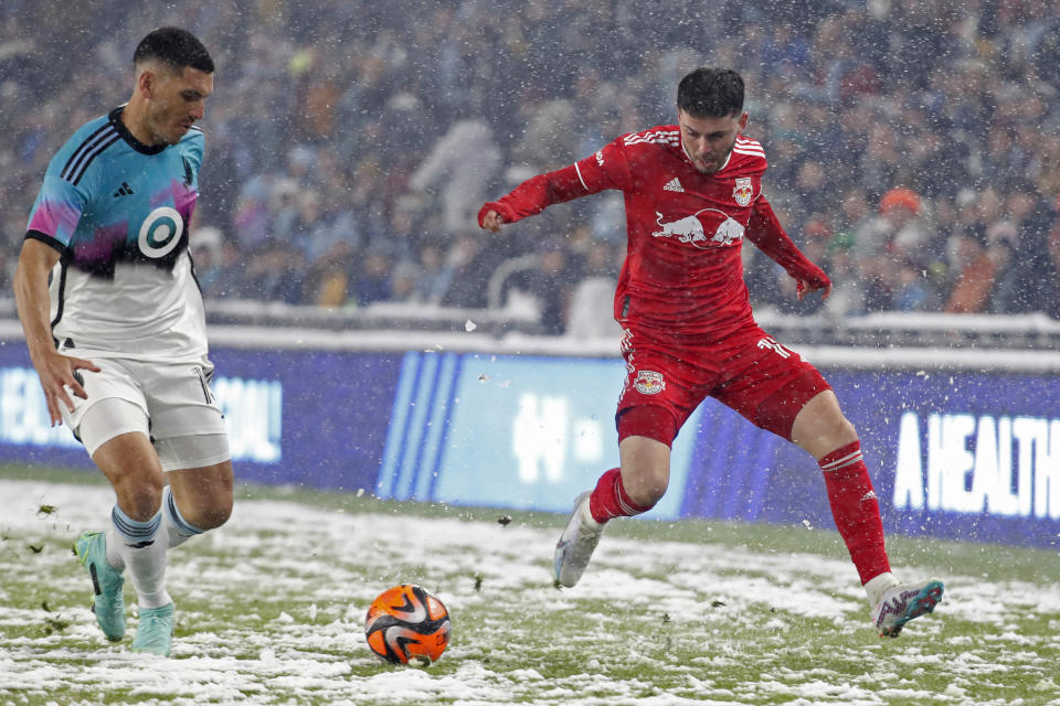 CORRECTS TO ST. PAUL, MINN., NOT MINNEAPOLIS - New York Red Bulls midfielder Lewis Morgan, right, races to the ball ahead of Minnesota United defender Michael Boxall (15) in the first half of an MLS soccer game Saturday, March 11, 2023, in St. Paul, Minn. (AP Photo/Bruce Kluckhohn)