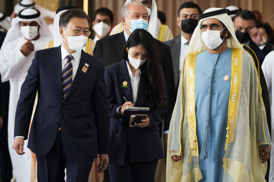 South Korean President Moon Jae-in, left, and Dubai ruler Sheikh Mohammed bin Rashid Al Maktoum, right, leave an event at Abu Dhabi Sustainability Week at Dubai Expo 2020 in Dubai, United Arab Emirates, Monday, Jan. 17, 2022. The president of South Korea on Monday vowed to world leaders that his fossil fuel-dependent country and the oil-rich United Arab Emirates would jointly expand their investments in renewable energy to tackle climate change. (AP Photo/Jon Gambrell)