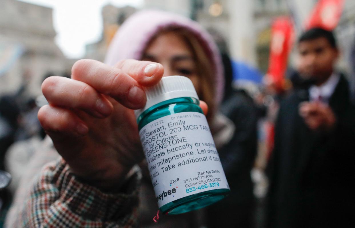 A pro-abortion activist displays abortion pills as she counter-protests during an anti-abortion demonstration on March 25, 2023 in New York City.